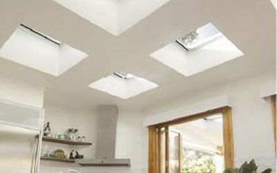 There are four skylights in the ceiling of a kitchen.