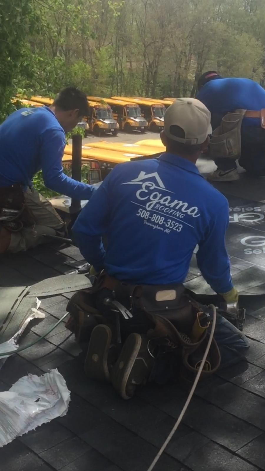 A group of men are working on a roof.