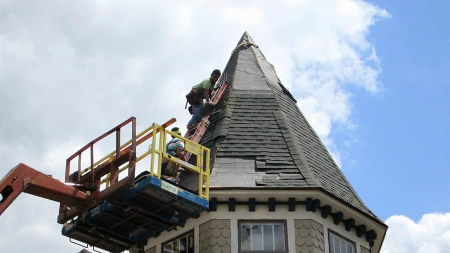 Two men are working on the roof of a building.