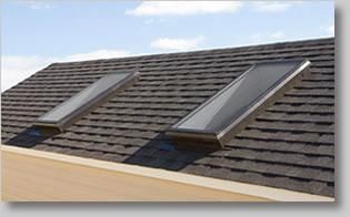 There are two skylights on the roof of a house.