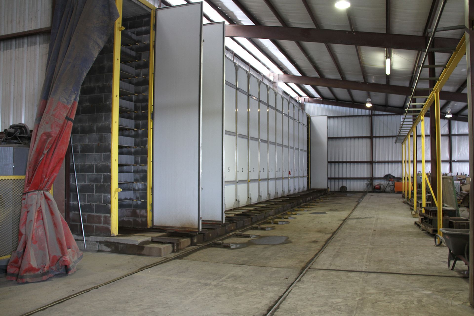 Industrial warehouse interior with large white storage units, metal beams, and a concrete floor