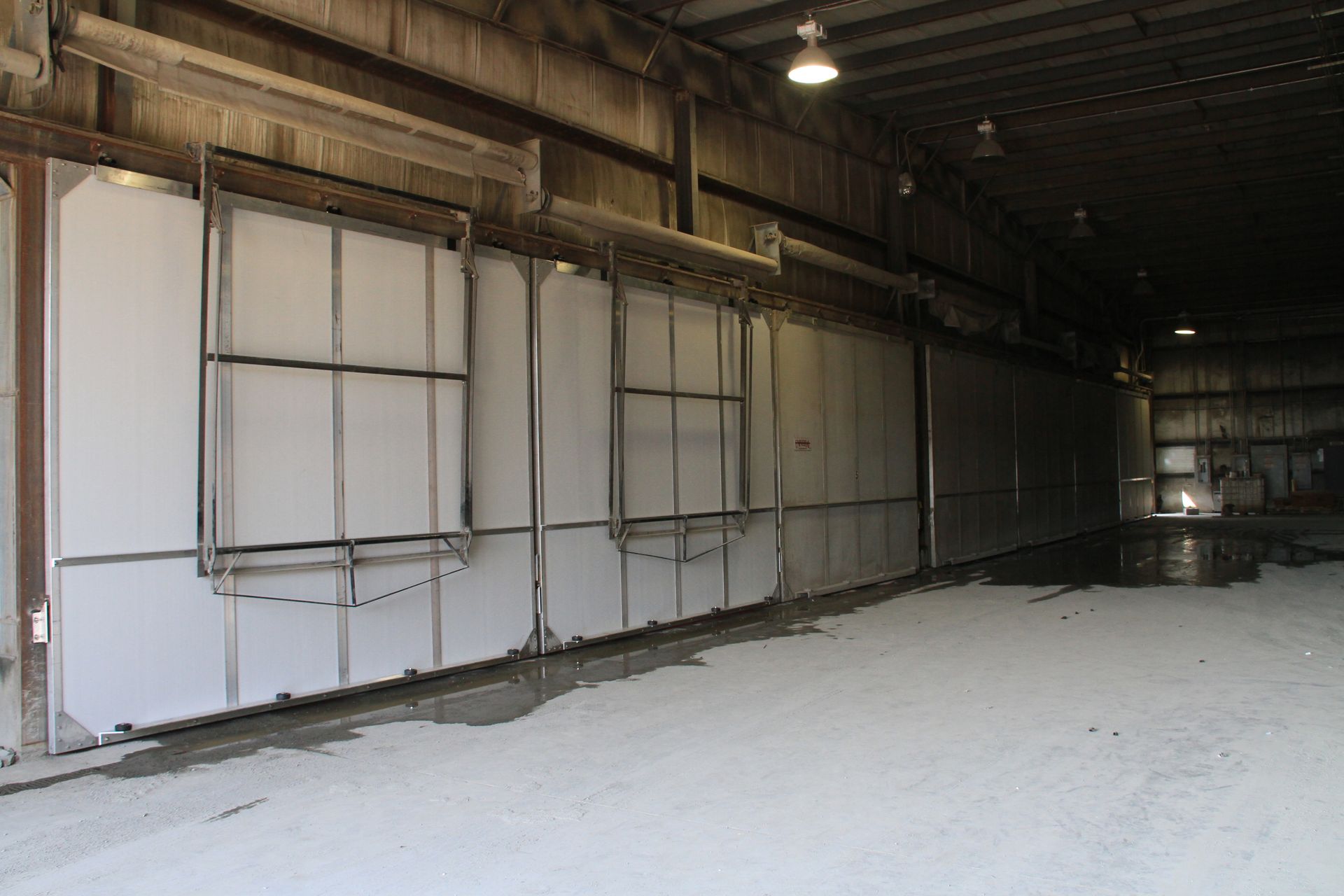 Empty warehouse interior with white wall panels and a concrete floor