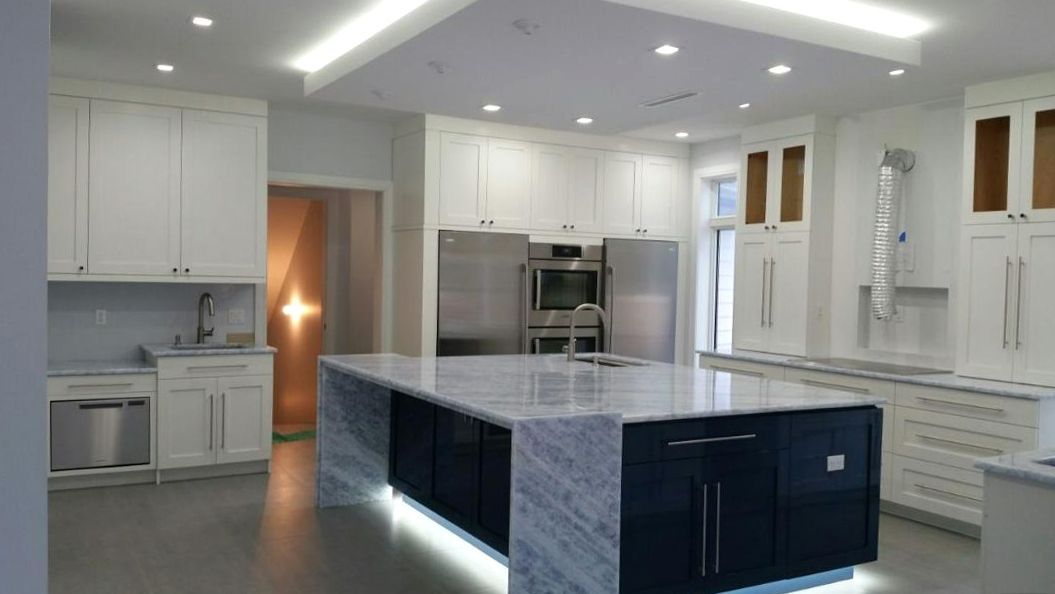 A kitchen with white cabinets and a countertop in the middle