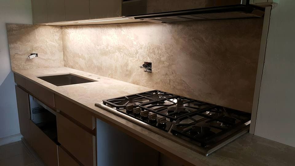 A kitchen with a stove top oven and a sink