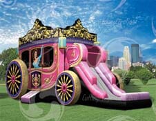 A pink carriage with a slide attached to it is sitting on top of a lush green field.