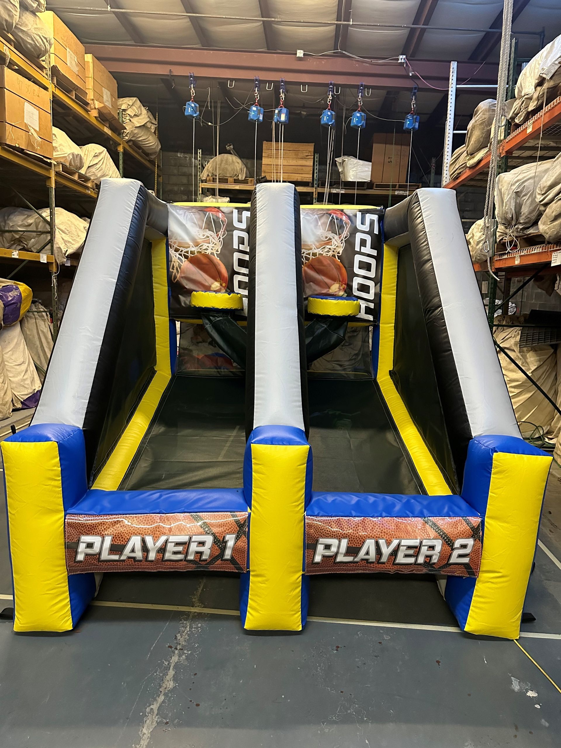 A basketball game is being played in a warehouse.