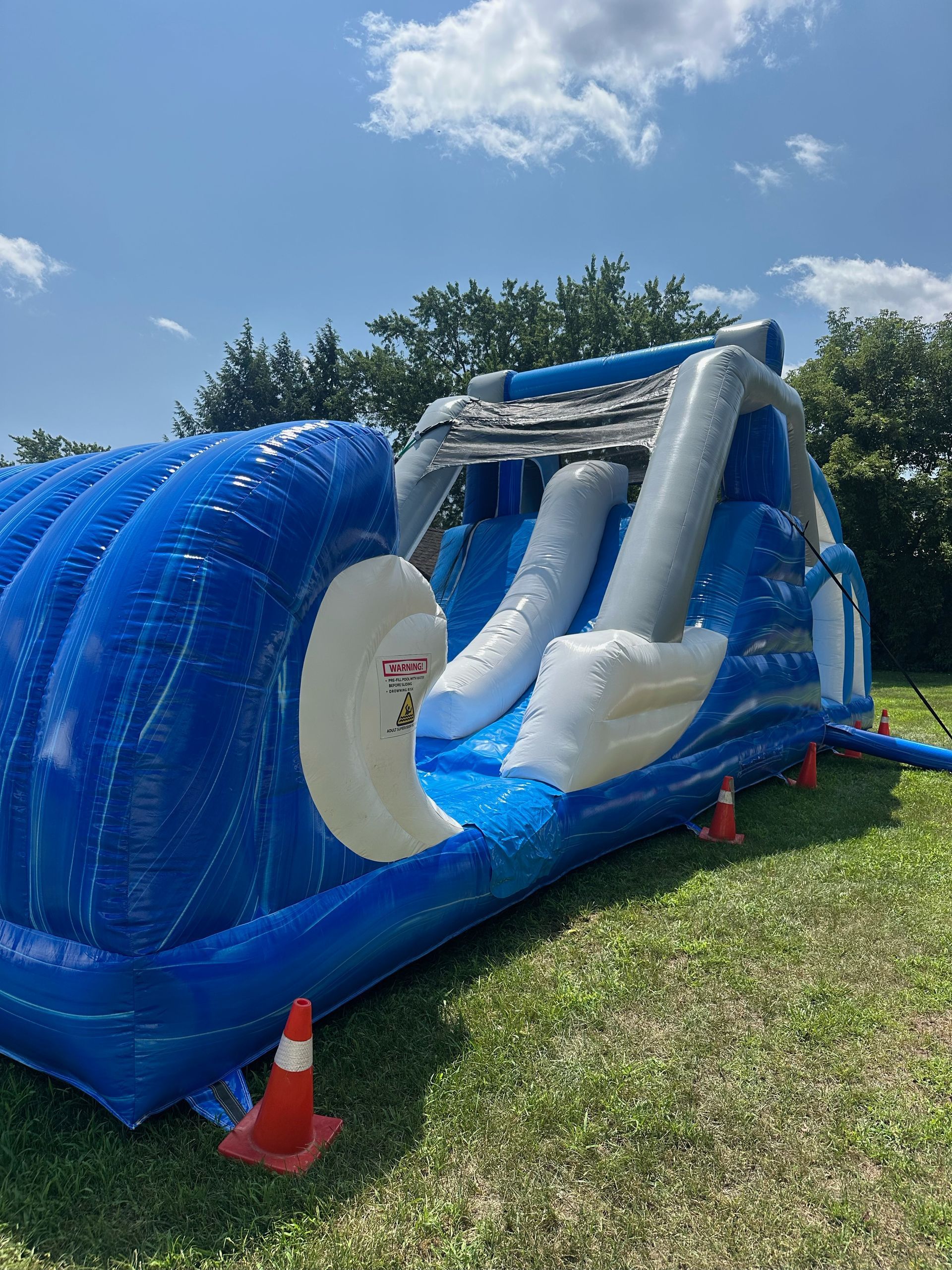 A large inflatable water slide is sitting on top of a lush green field.