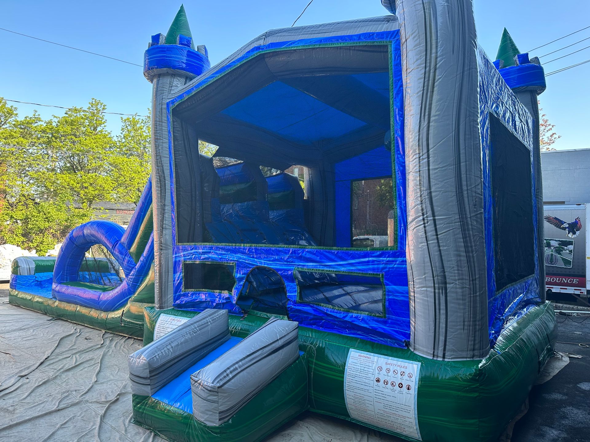 A blue and green bouncy house with a slide attached to it.