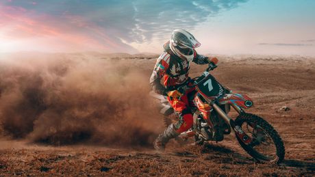 A person is riding a dirt bike on a dirt road.