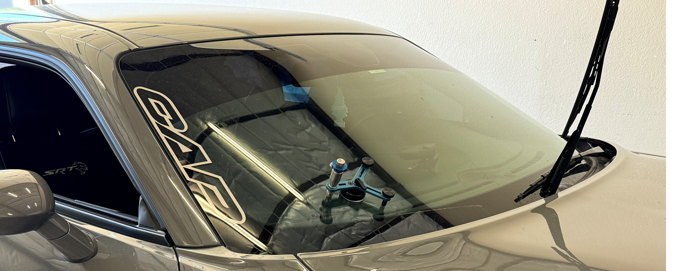 A car with a broken windshield is sitting in a garage.