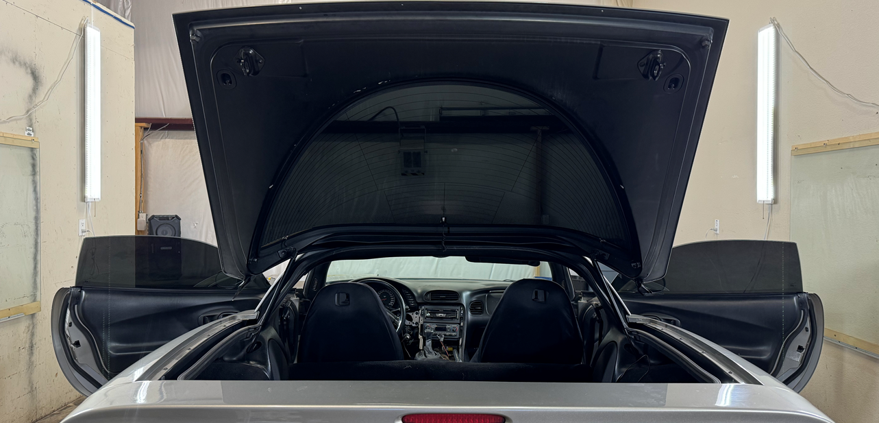 The hood of a car is open and the doors are open.