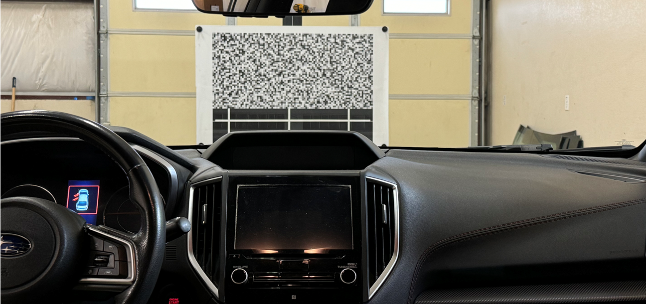 The dashboard of a subaru is shown in a garage.
