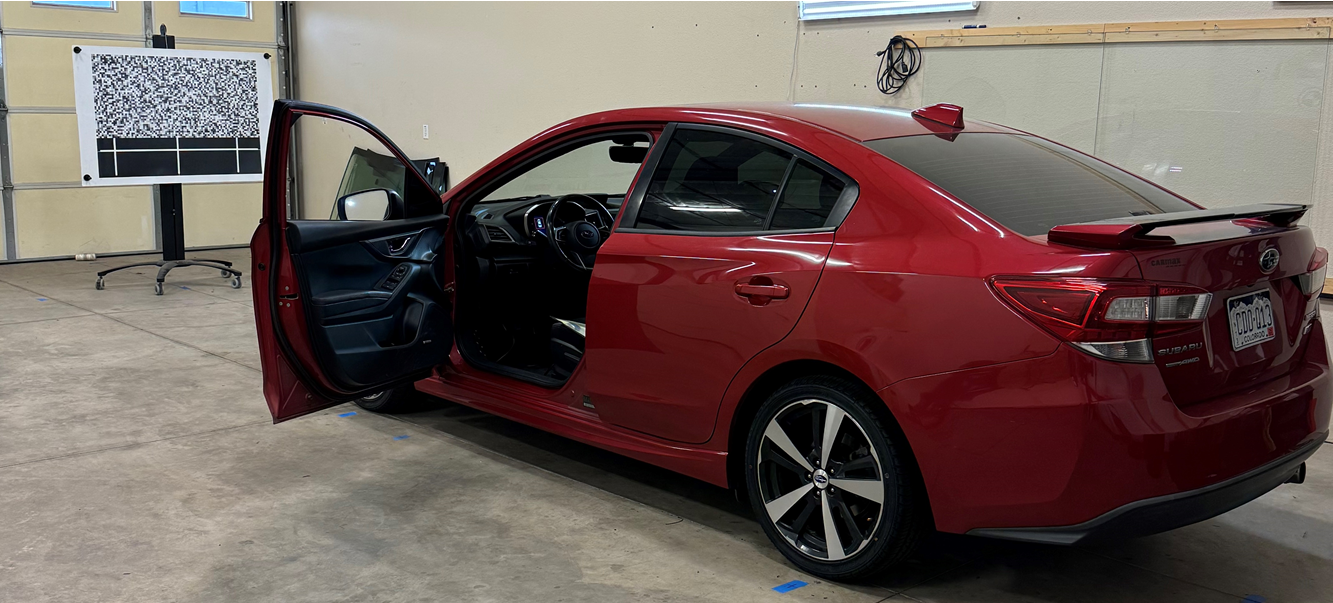 A red car is parked in a garage with its doors open.