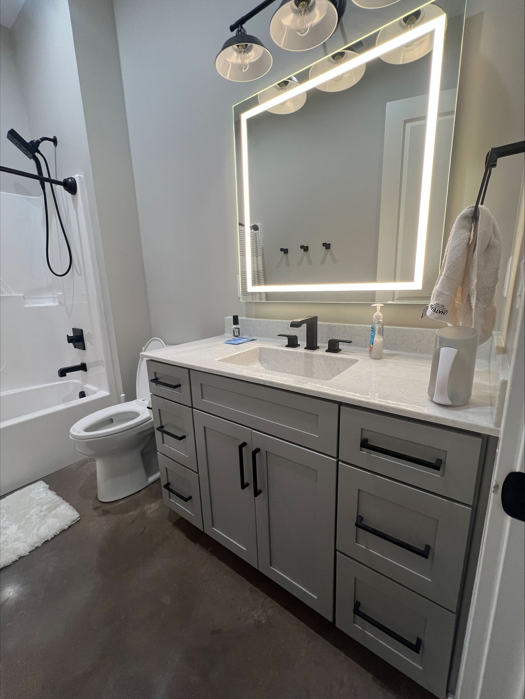 A bathroom with a sink , toilet , bathtub and mirror.