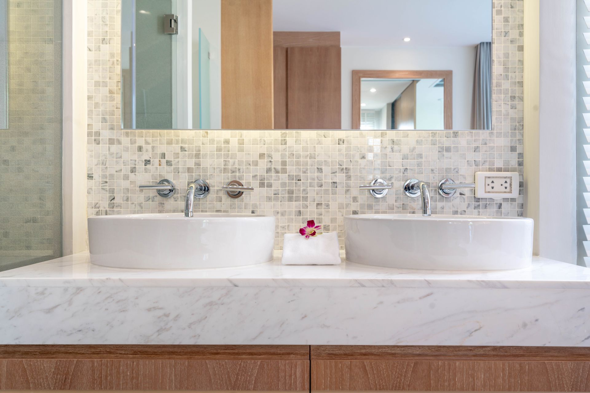 A bathroom with two sinks and a large mirror.