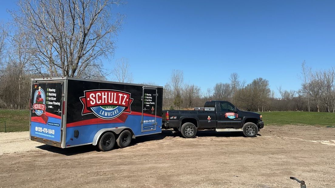 A truck is pulling a trailer in a dirt field.