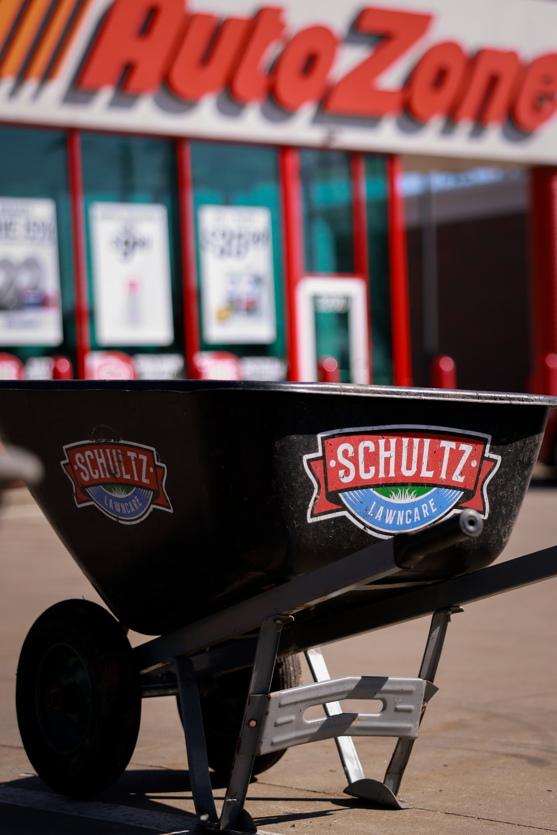 A schultz wheelbarrow is parked in front of an autozone