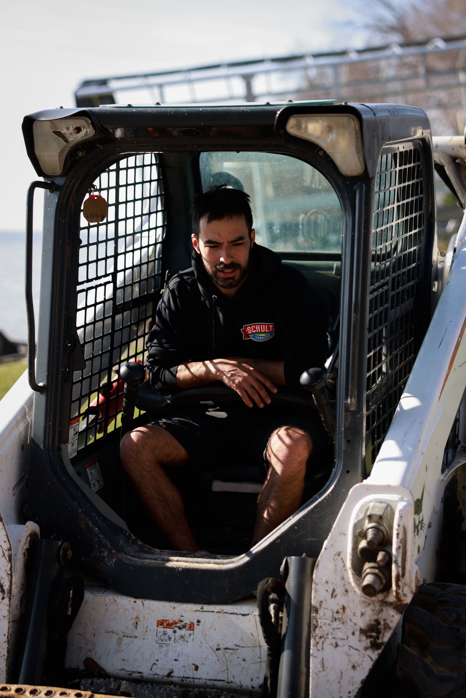 A man is sitting in the cab of a bulldozer.