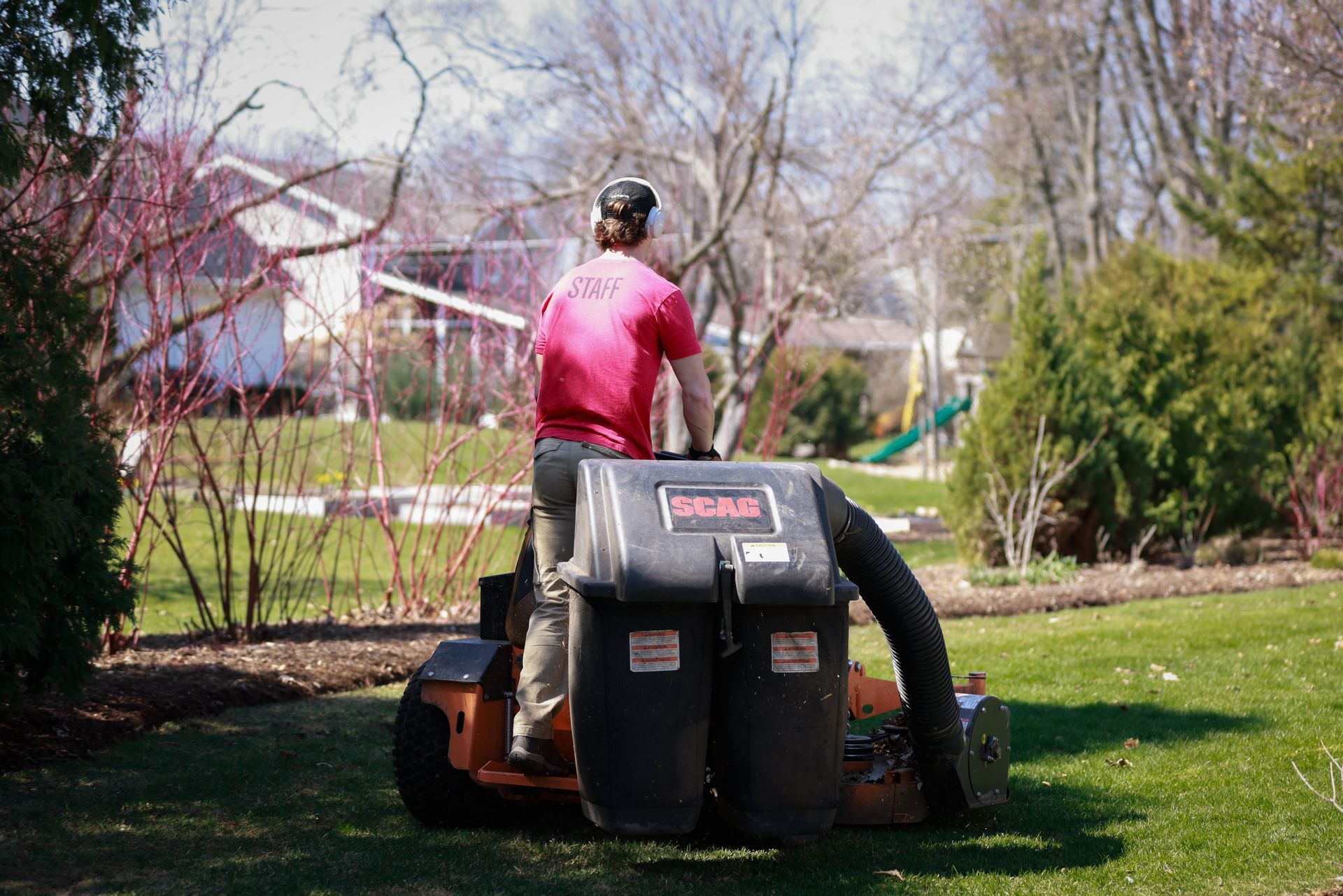 A man is riding a lawn mower in a yard.