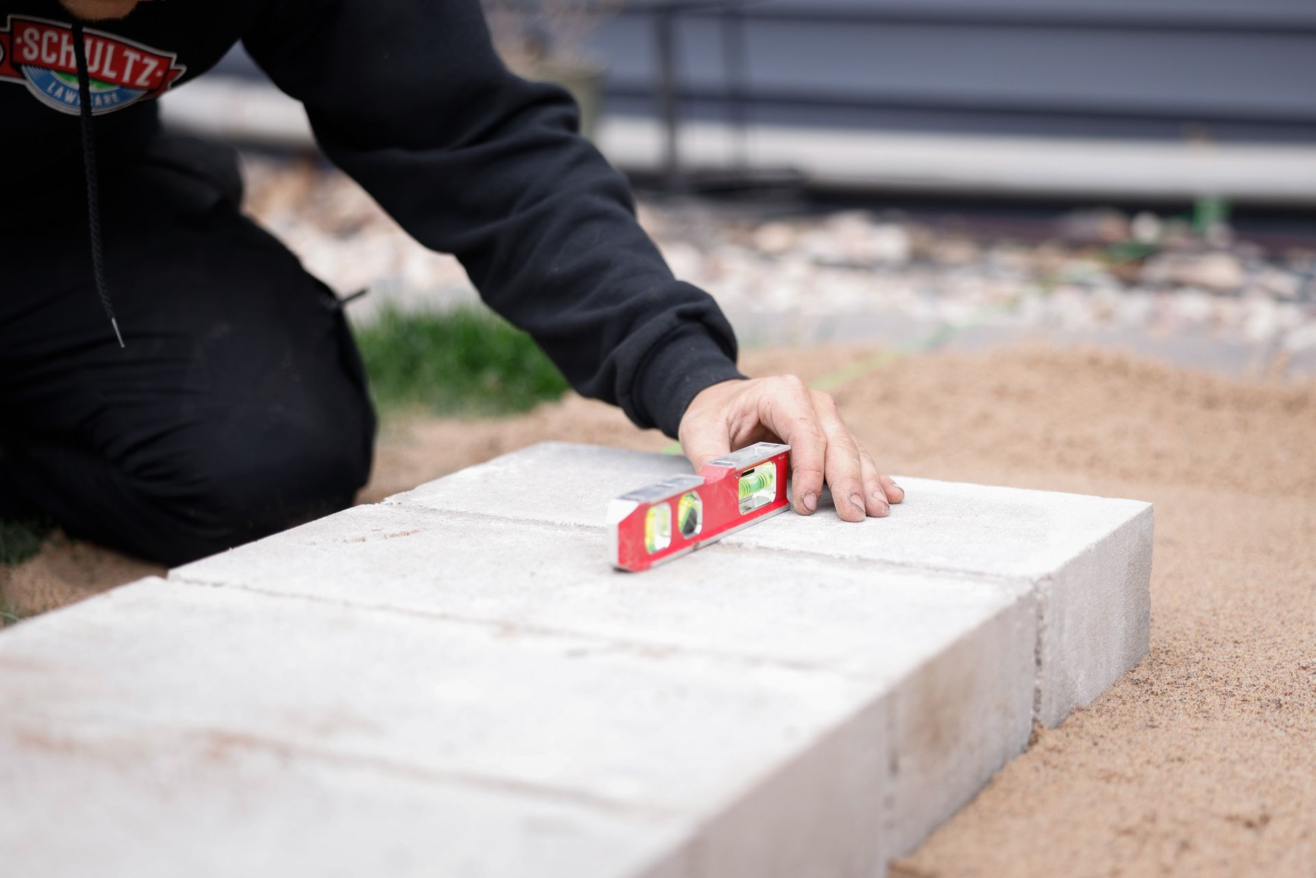 A person is using a level to measure the level of a concrete slab.