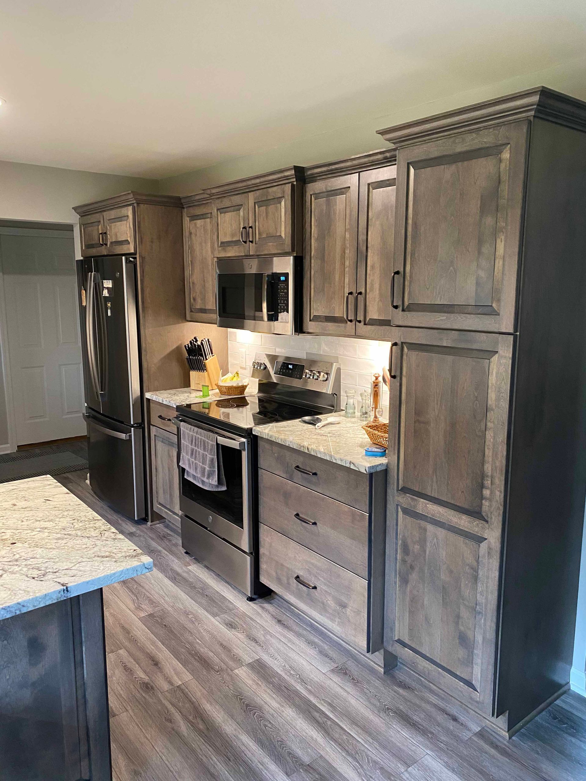 A kitchen with stainless steel appliances and wooden cabinets.