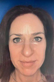 A close up of a woman's face with a blue background.