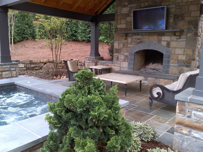 a patio with a fireplace and a television above it