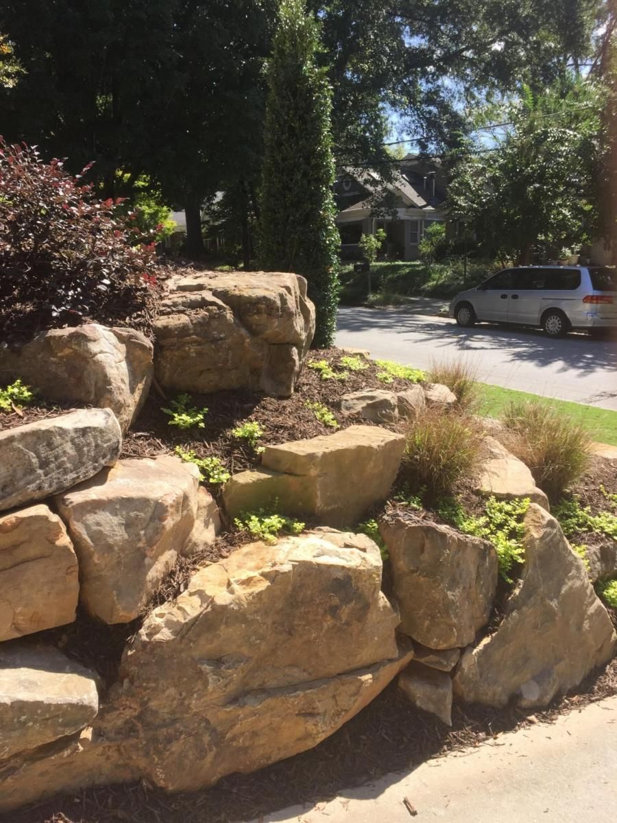 a white van is parked on the side of the road next to a rock wall