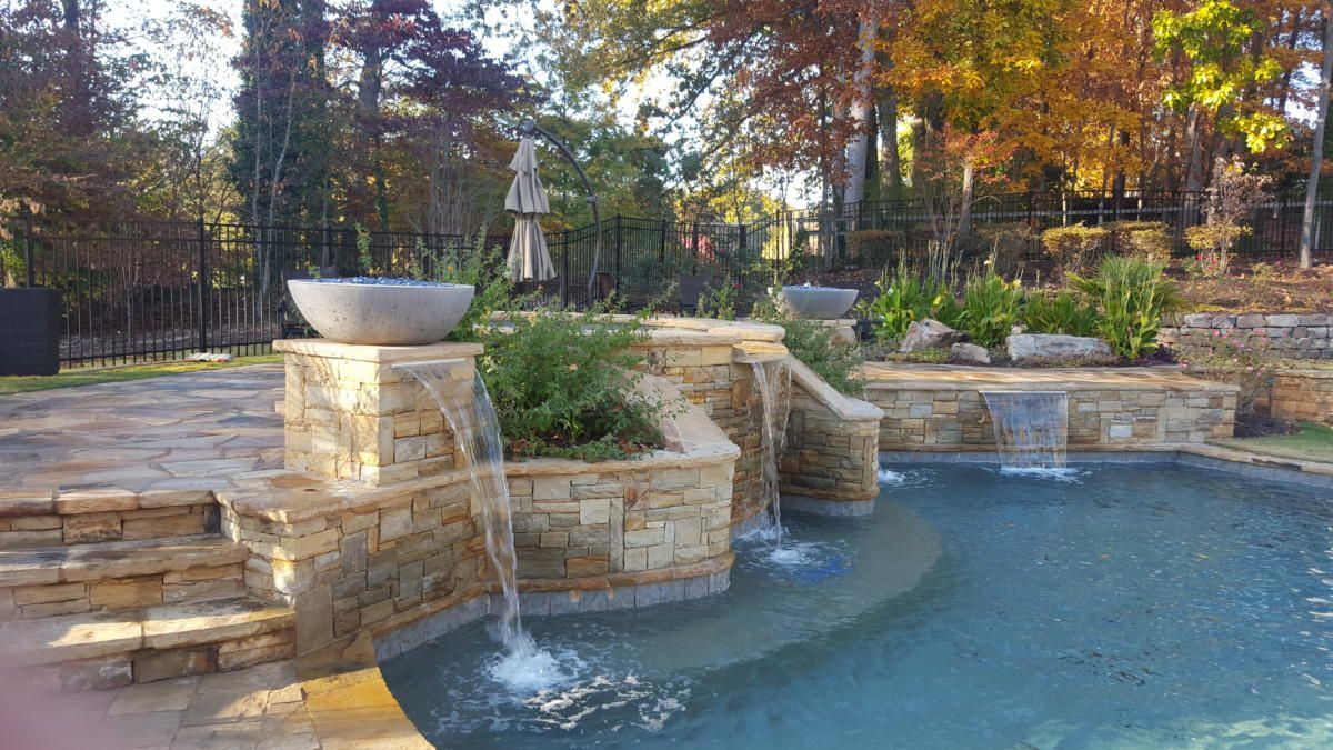 a large swimming pool with a waterfall in the middle of it .