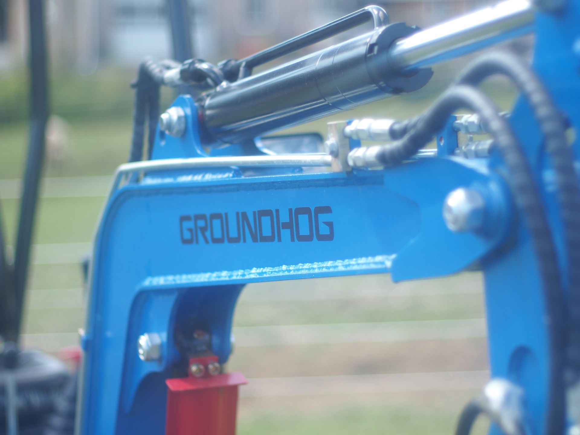 Blue Groundhog mini excavator arm with hydraulic cylinder.