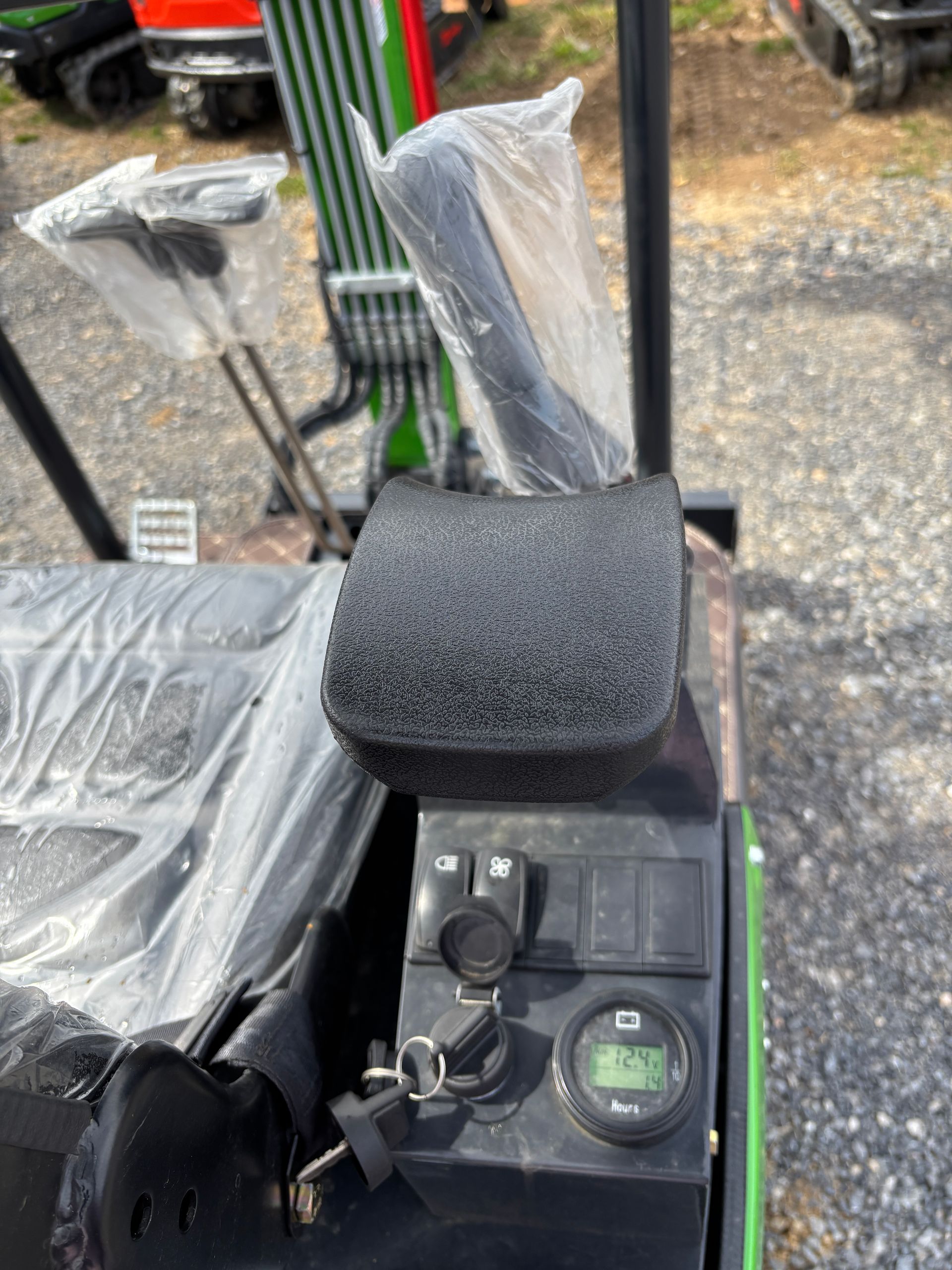 Close-up of a mini-excavator control panel with keys, switches, and a digital display.