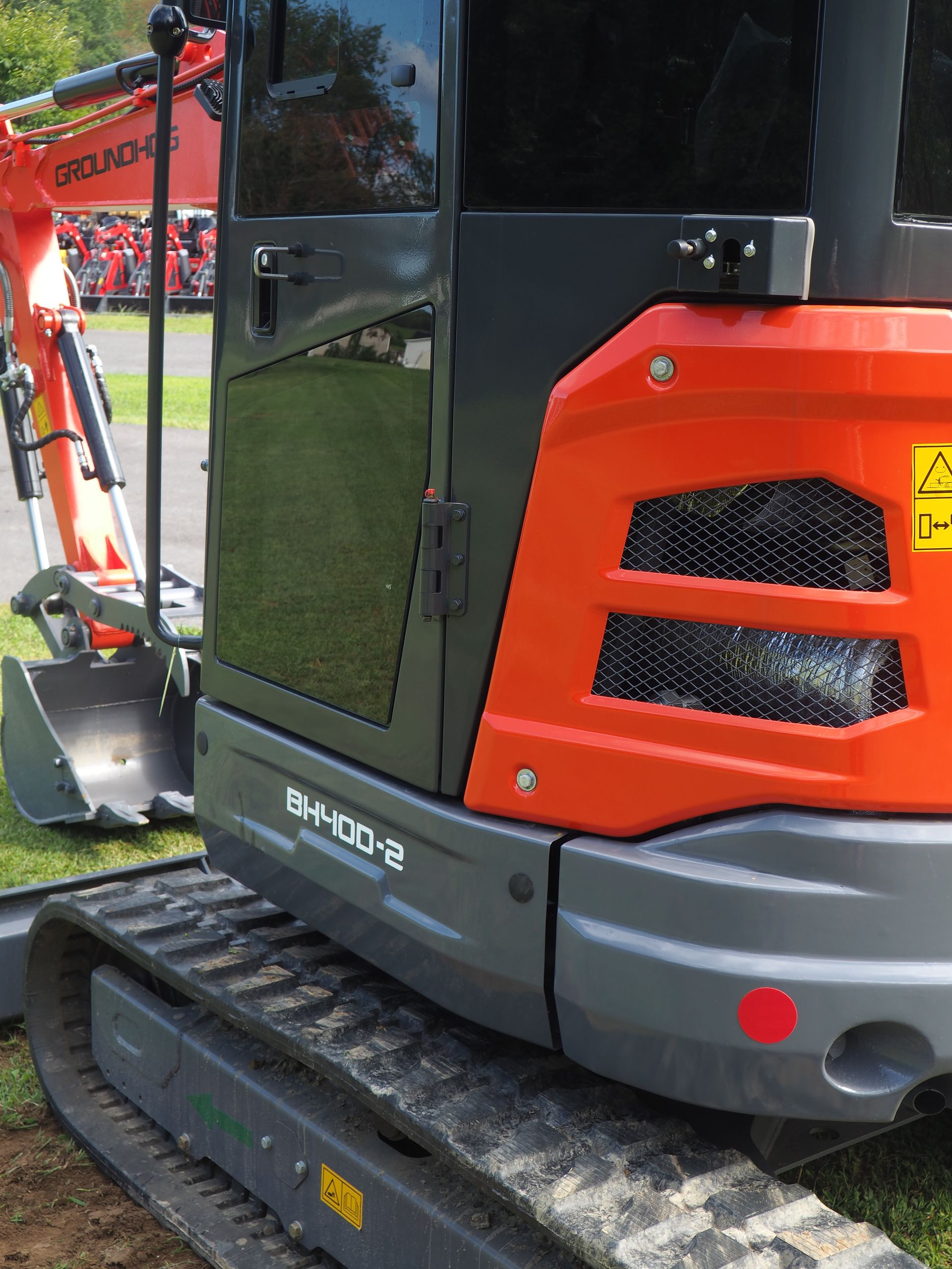 Orange and gray Kubota excavator, with black door and track.