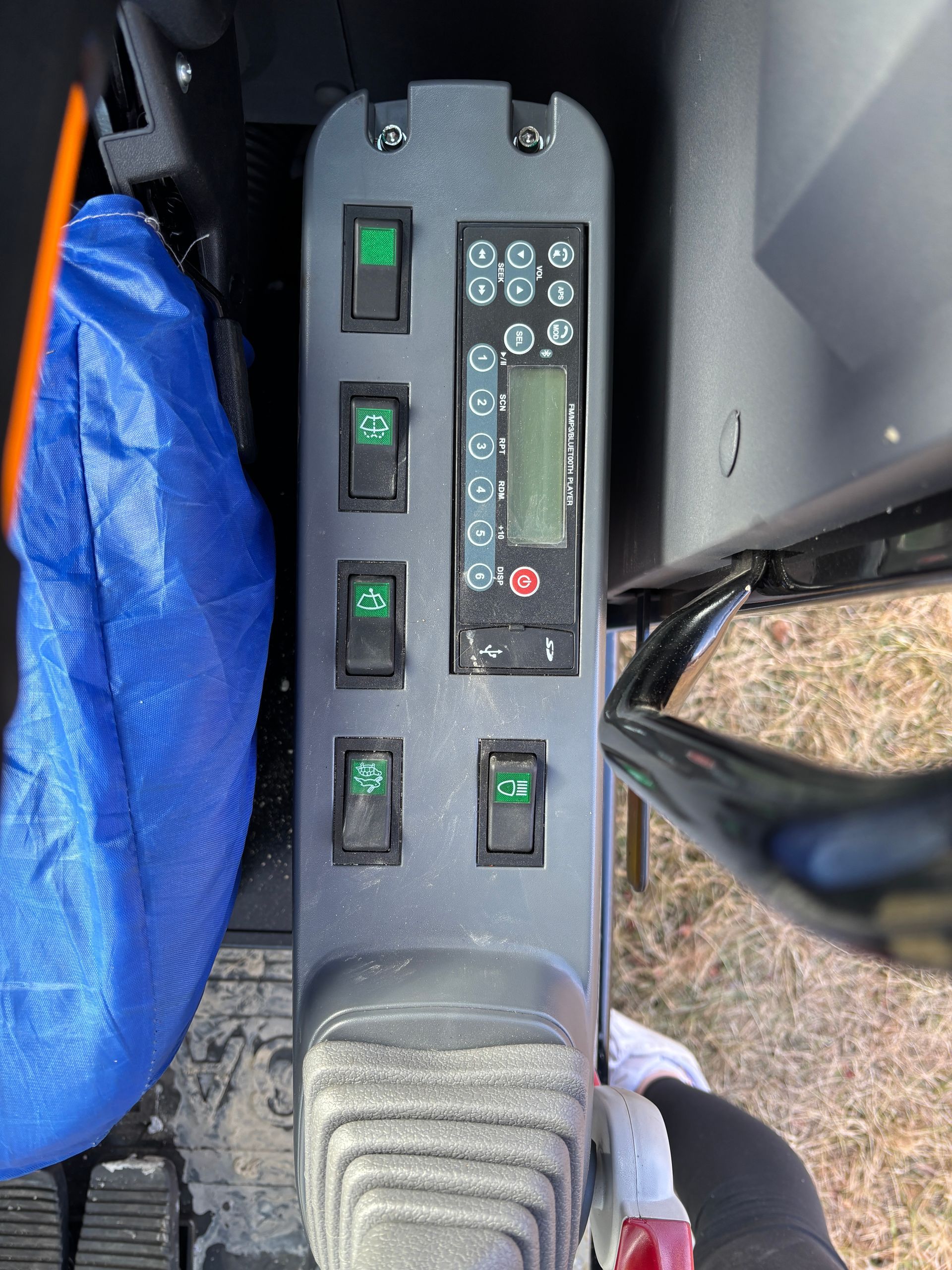Panel with green switches and a digital display inside a vehicle.