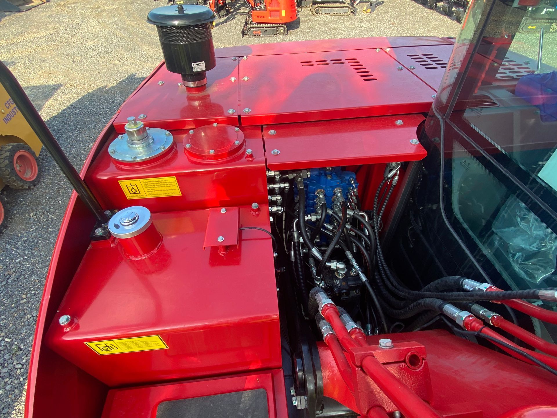 Red machinery engine compartment with various tanks and hoses.