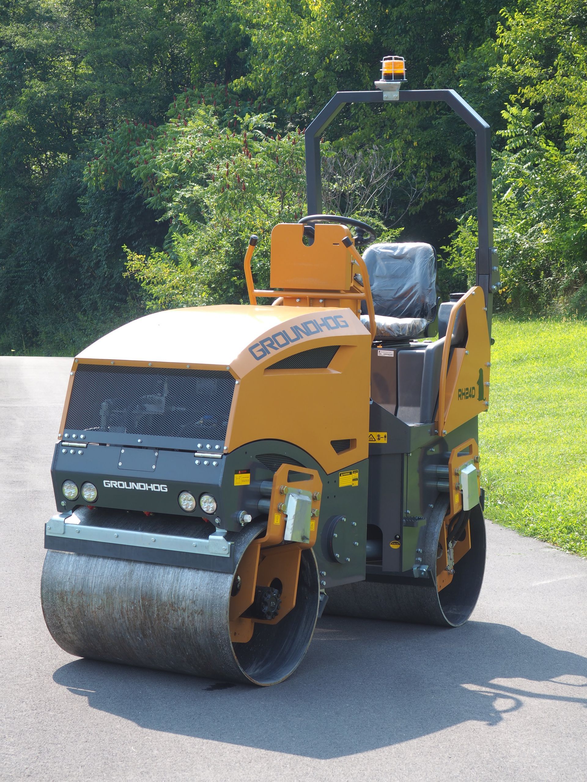 Yellow and black road roller on asphalt, preparing a road surface.