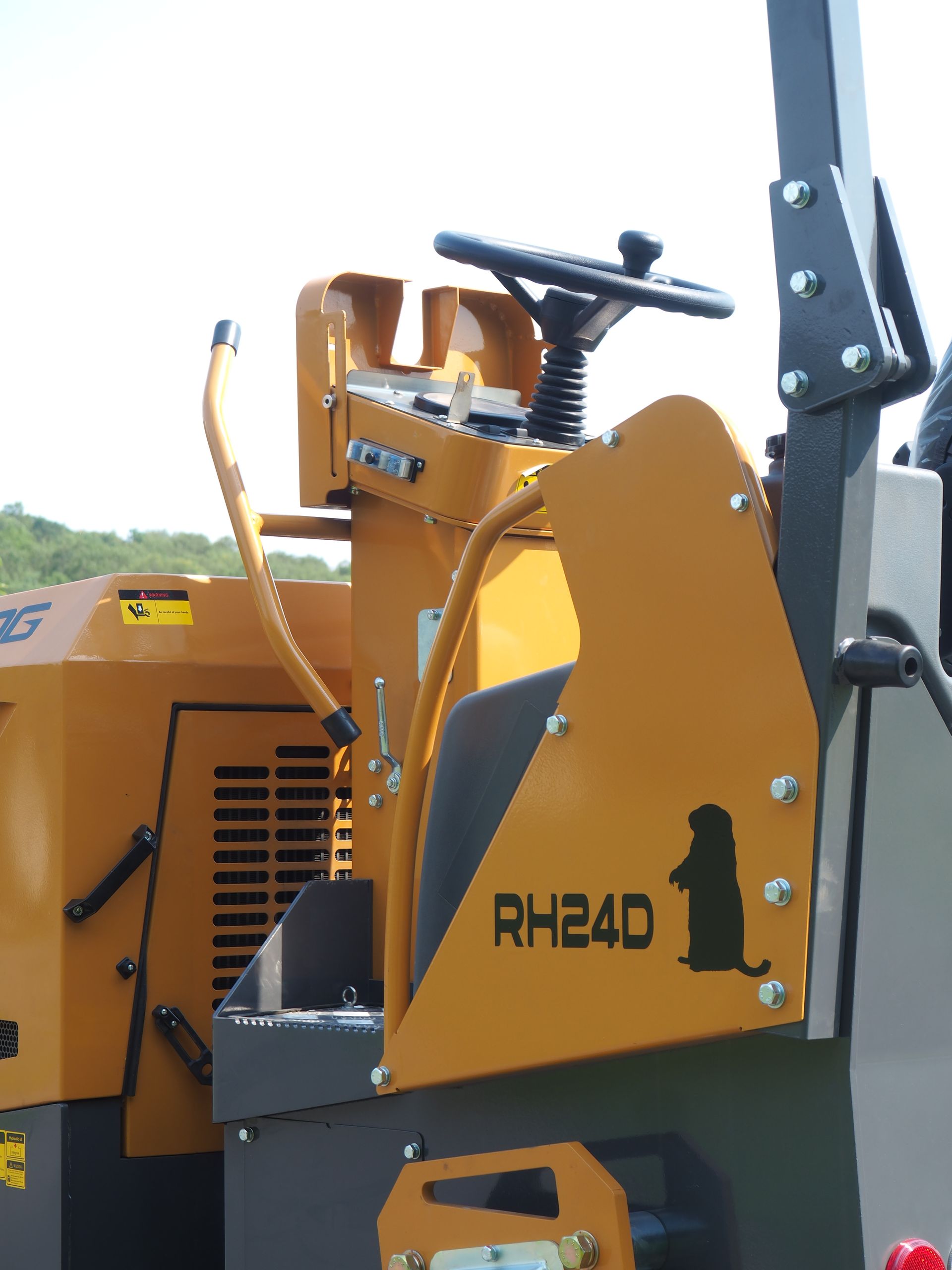 Yellow road roller with a seat, steering wheel, and the text RH24D and a groundhog graphic.