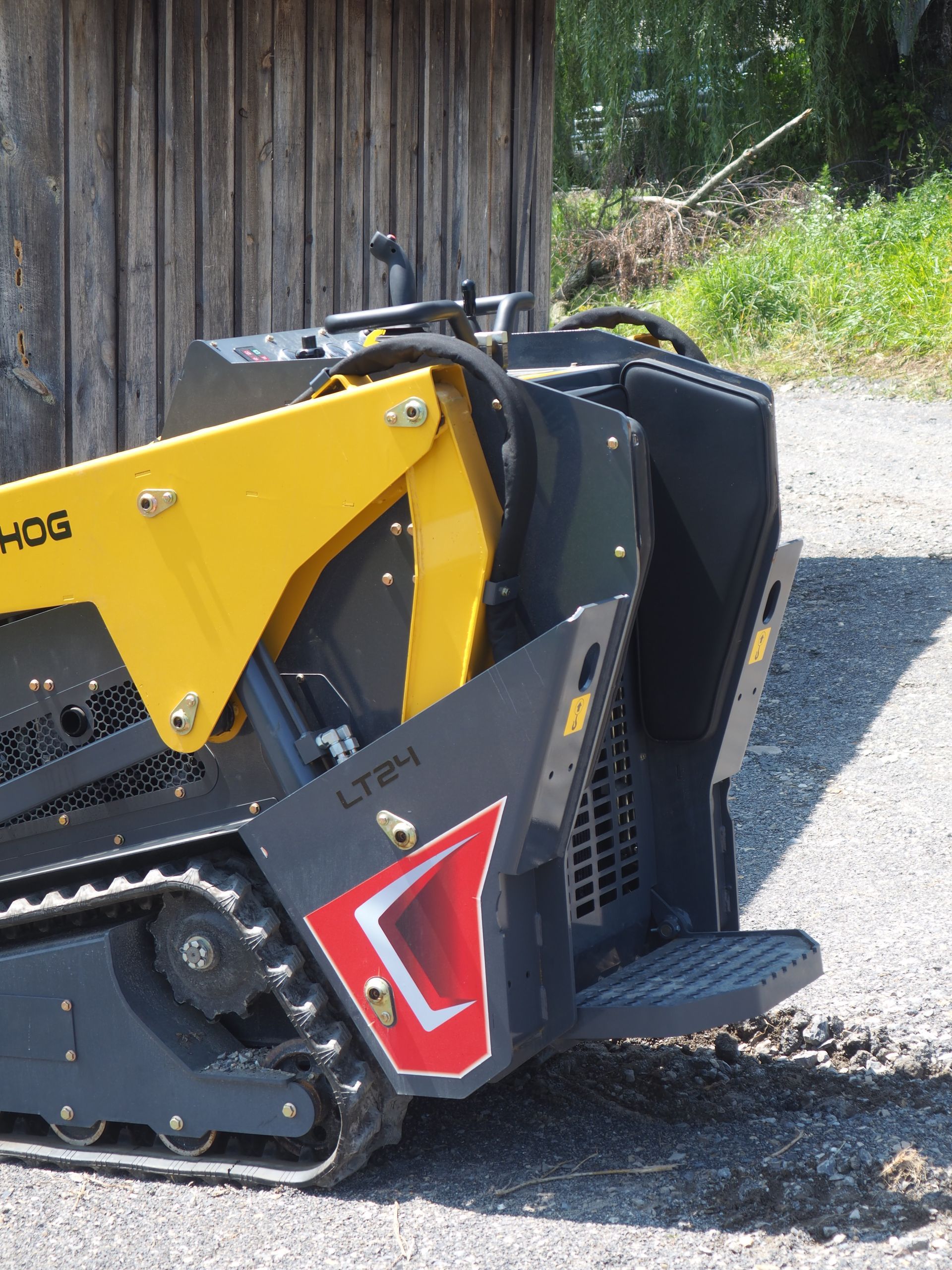 Yellow and black compact track loader, outdoors.