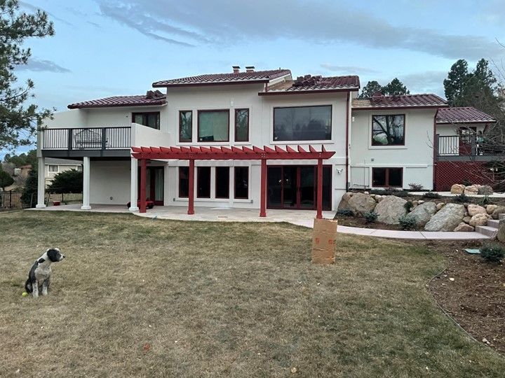 White residential house with a dog in the backyard
