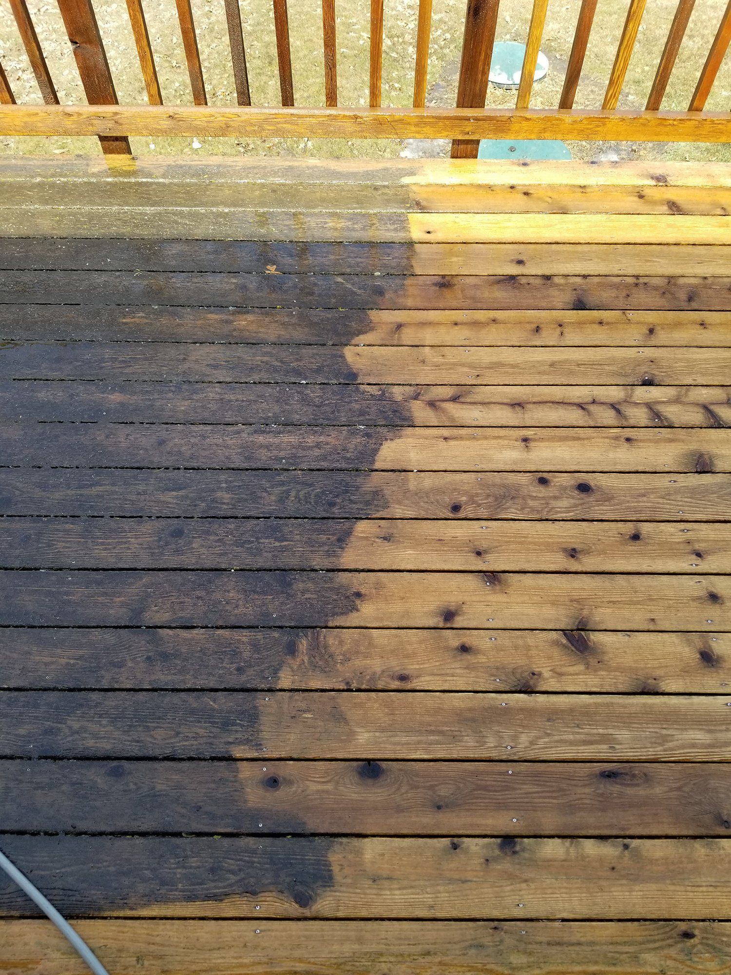 A wooden deck is being cleaned with a pressure washer.