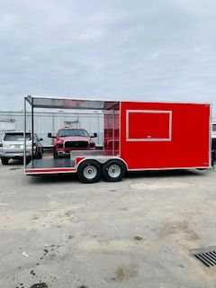 Red concession trailer with serving window and display case parked on a lot