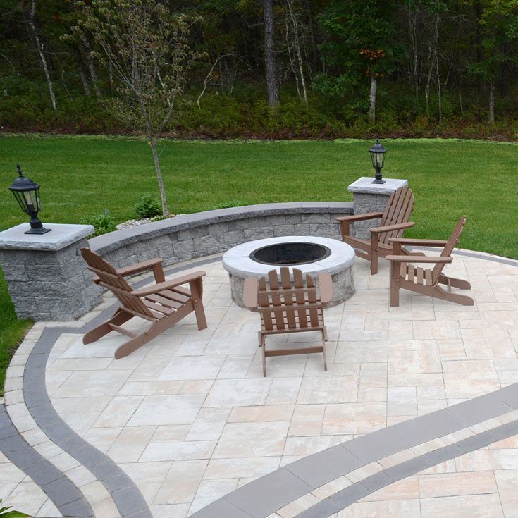 A patio with chairs and a fire pit in the middle