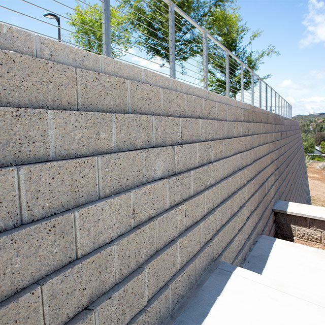 A brick wall with a metal railing on top of it