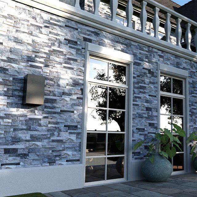 A brick building with a balcony and a plant in front of it