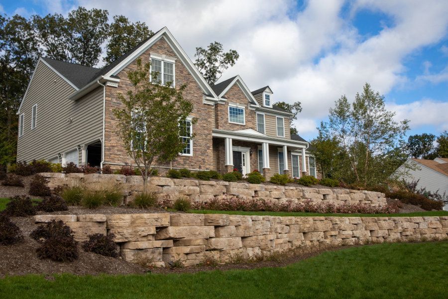 A large house with a stone wall in front of it