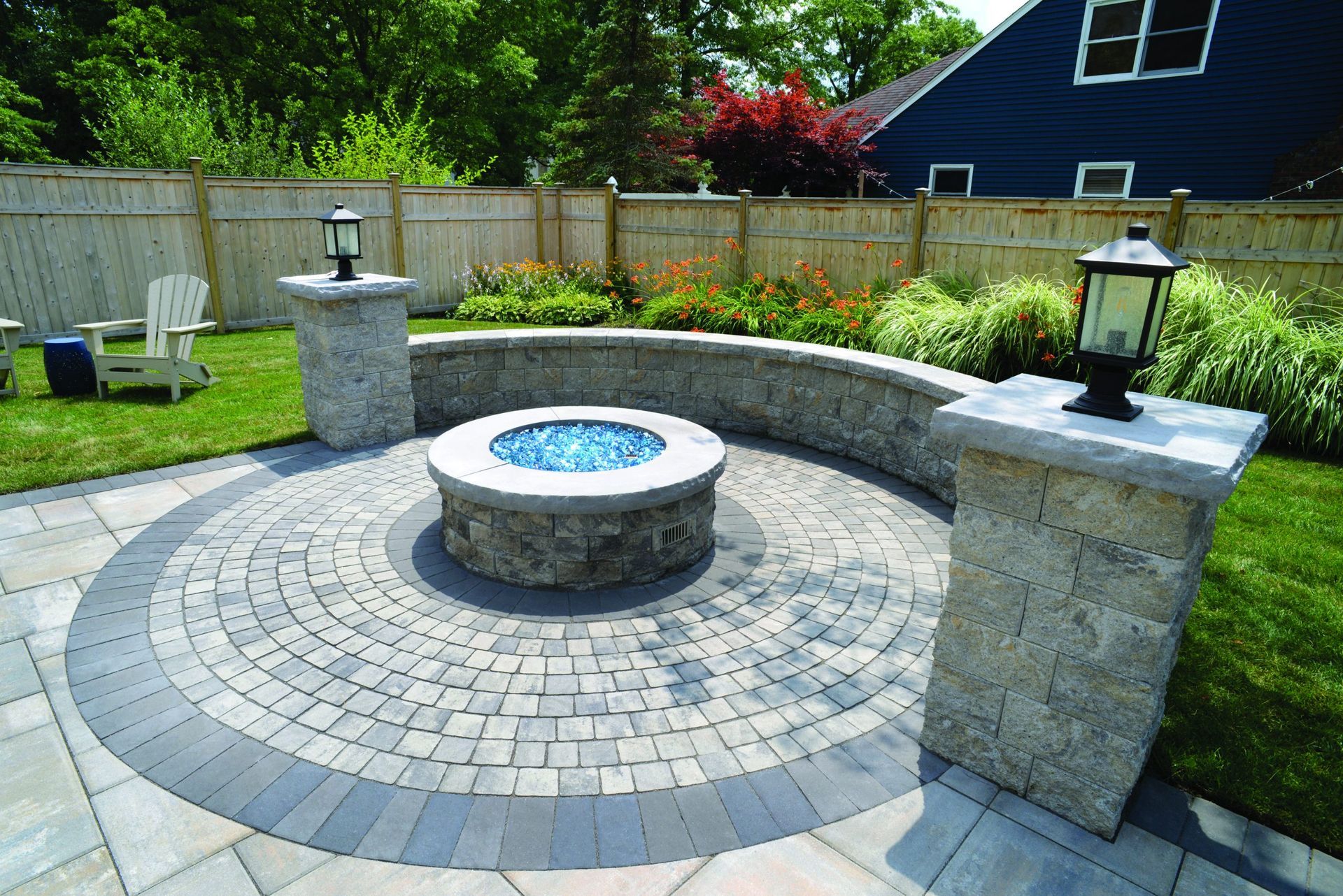 A fire pit in the middle of a patio in a backyard