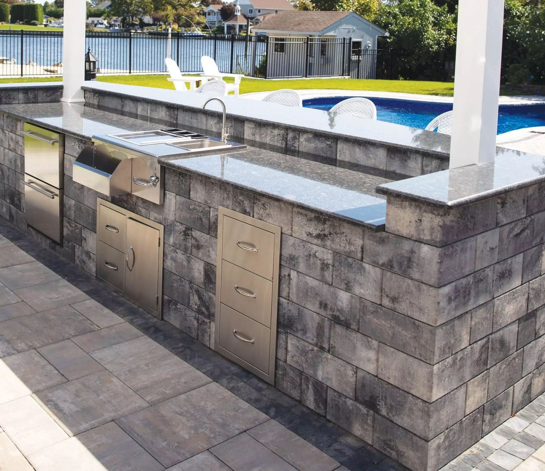 A large outdoor kitchen with a stainless steel grill