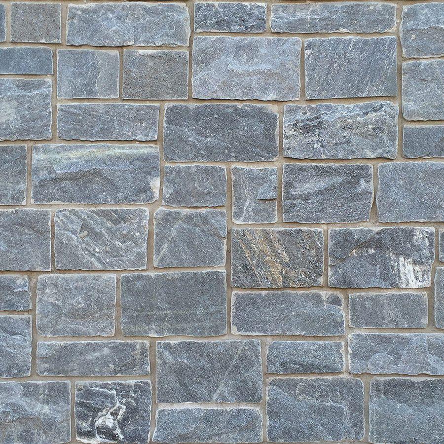 A close up of a brick wall with gray bricks