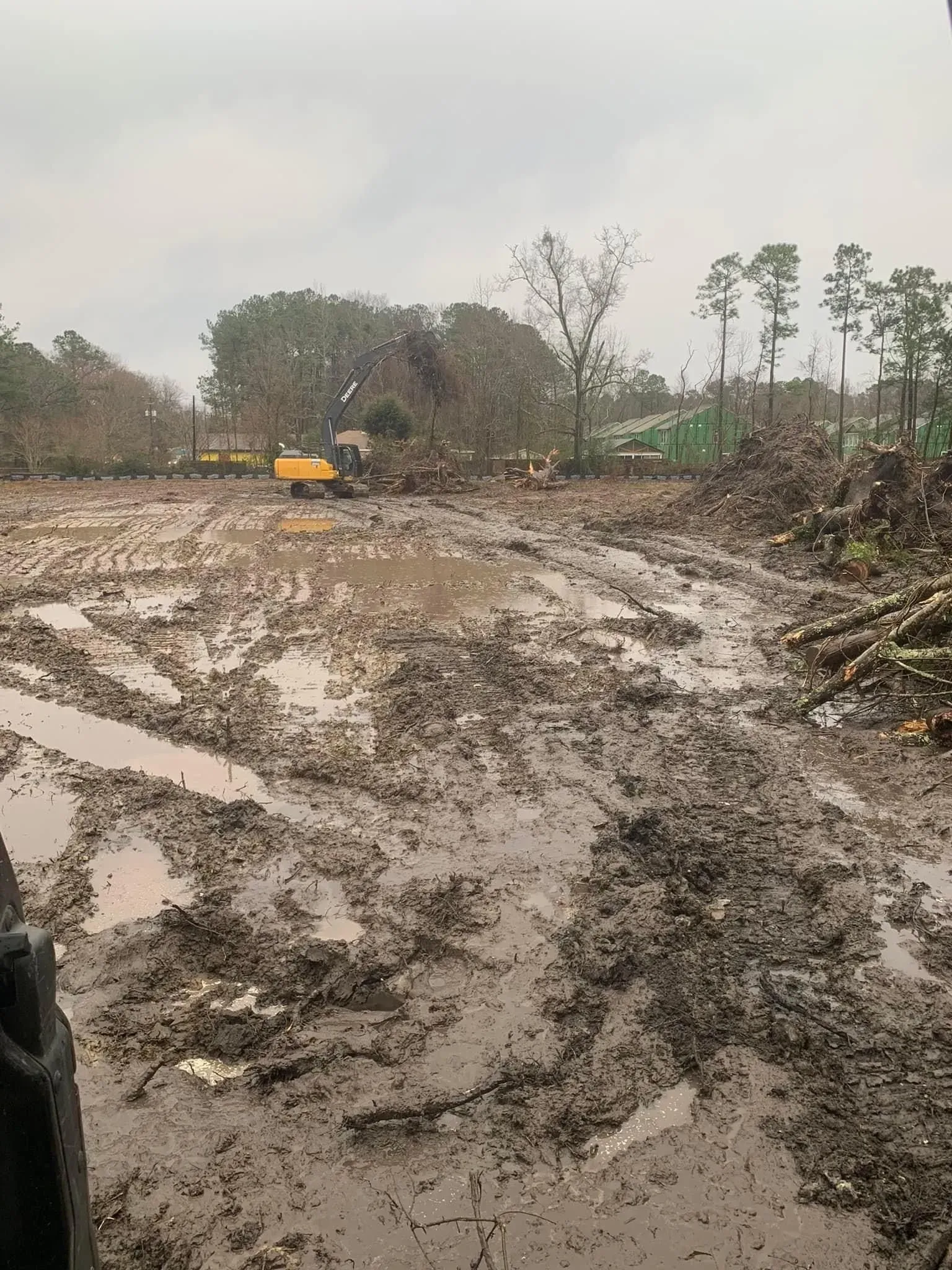Muddy field with construction equipment; overcast sky.