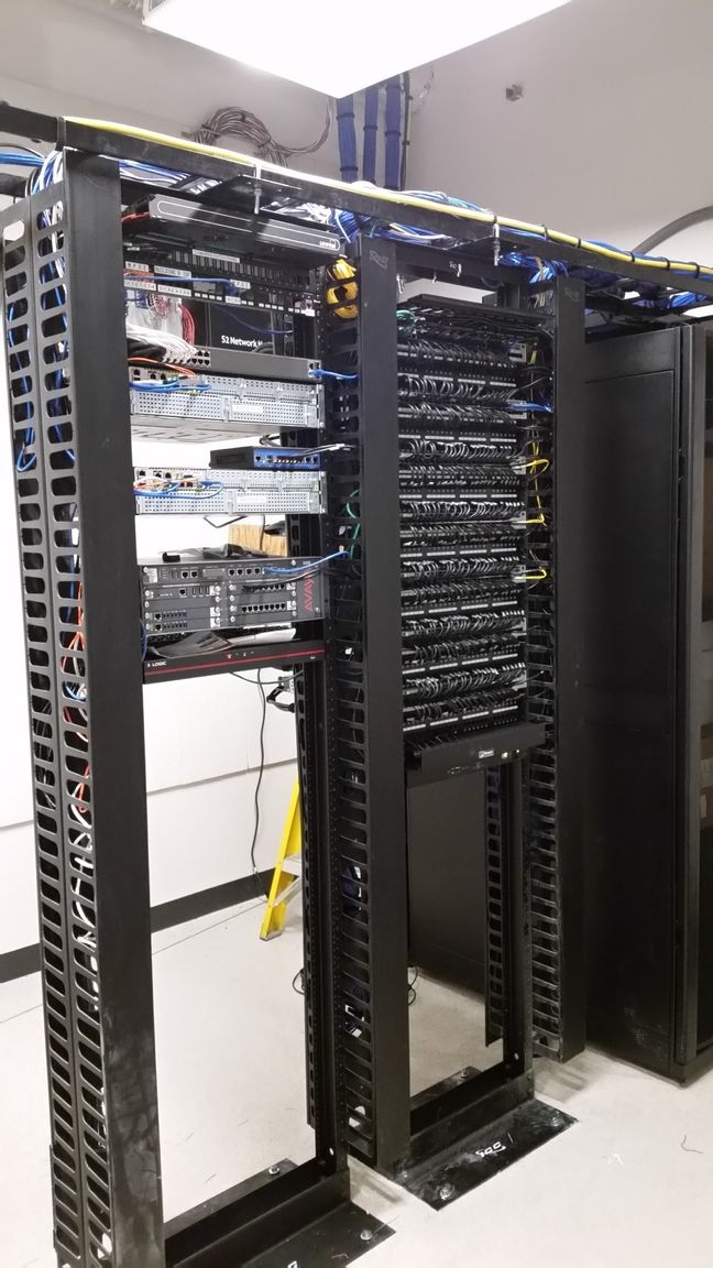 A server rack with a lot of wires hanging from it