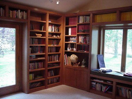 A room with a lot of bookshelves and a window